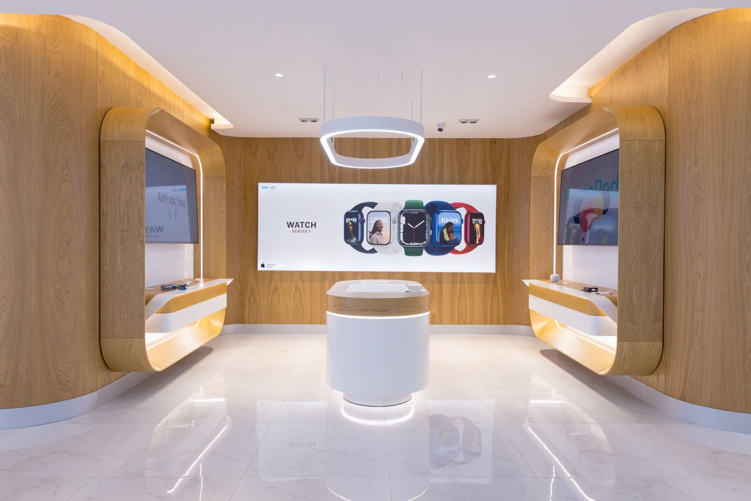 Al Watikon store interior: white display counter under an oval light ring, timber wall behind