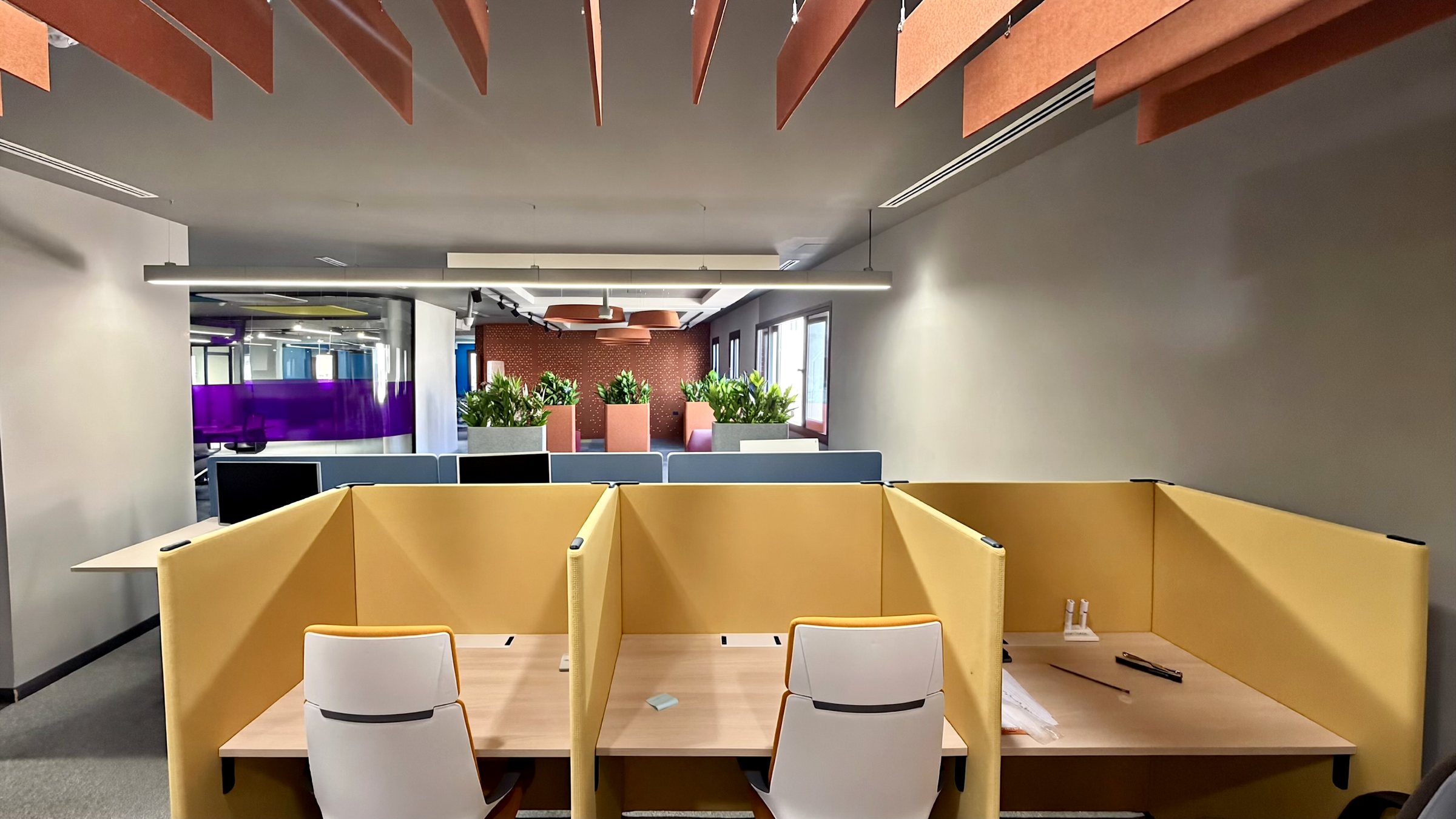 Photo: yellow focus booths as built, with the purple glass rooms beyond