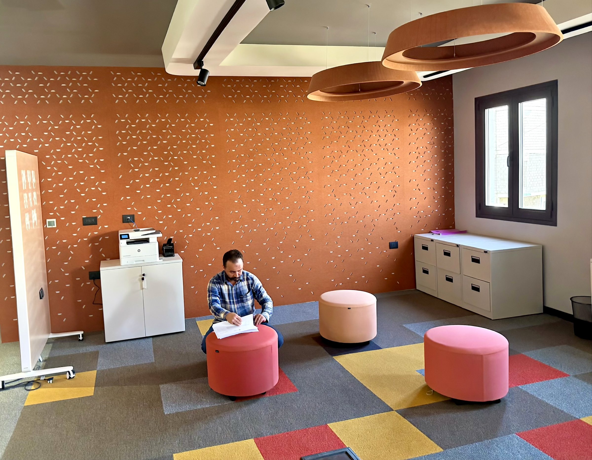 Photo: brainstorming room as built, orange perforated wall and coloured carpet