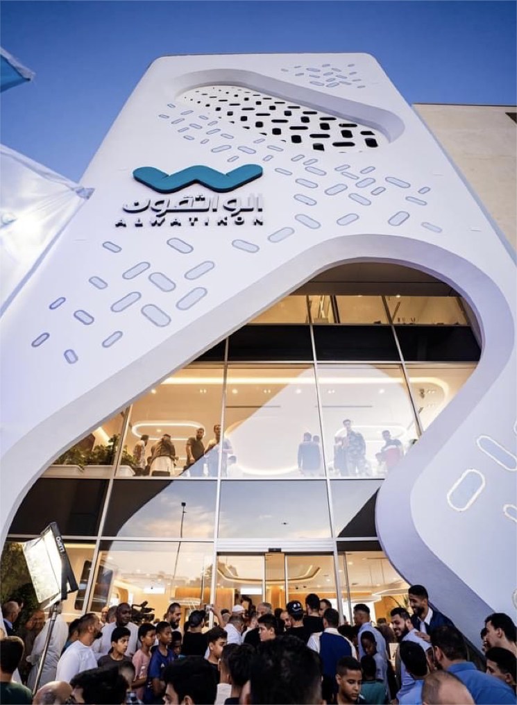 Al Watikon flagship facade on opening day, looking up at the perforated arch